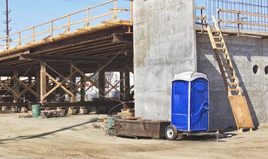 a row of blue porta potties set up on a job site